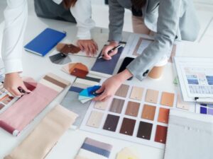 Interior Designer durante la progettazione con planimetrie e campioni di material
